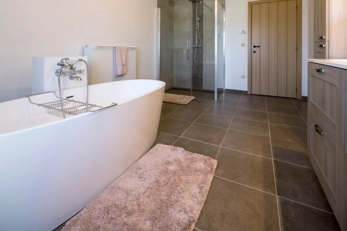 Bright bathroom with a freestanding tub, walk-in glass shower, wood vanity and timber door.